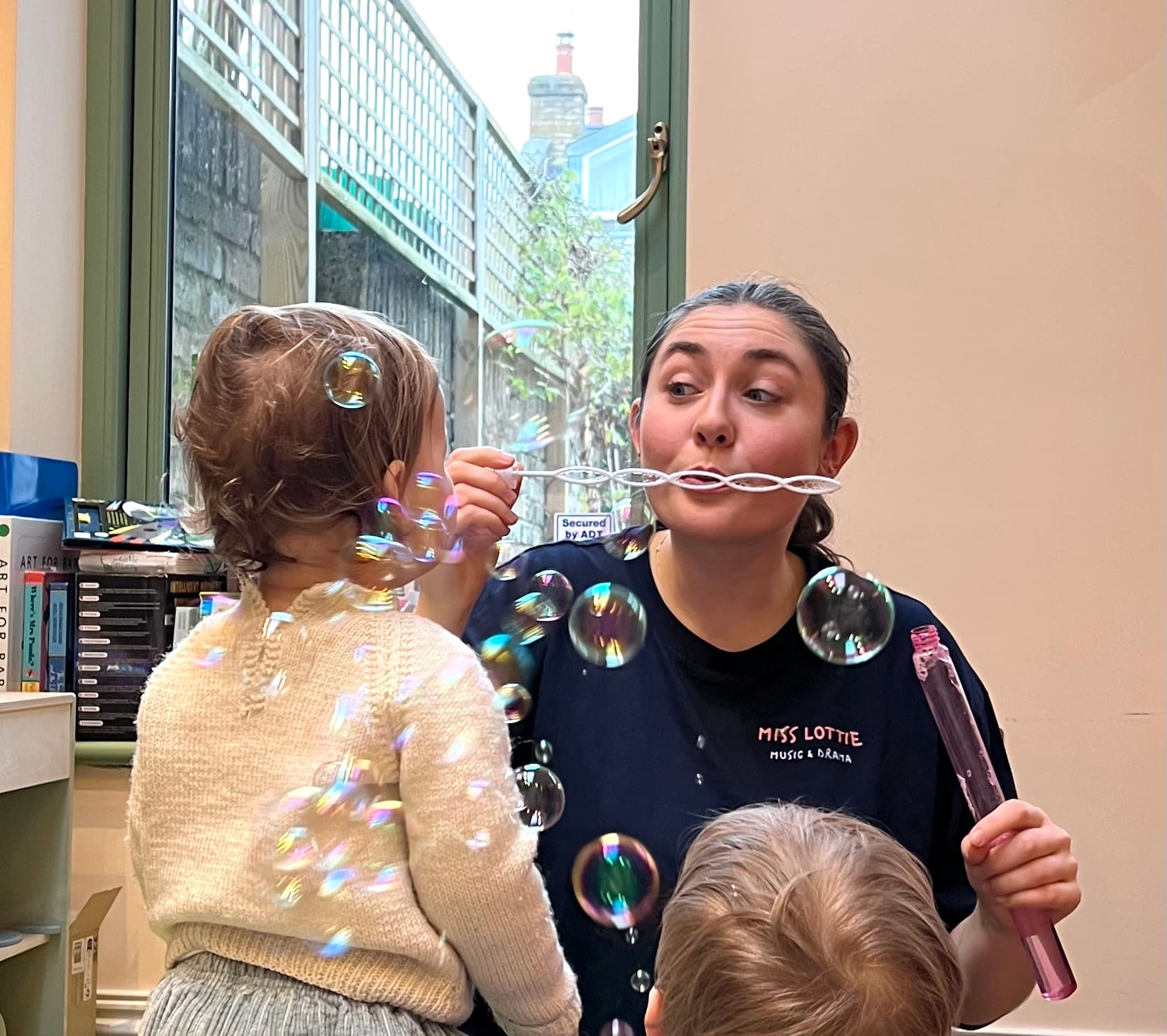 Lottie blowing bubbles with enchanted toddlers